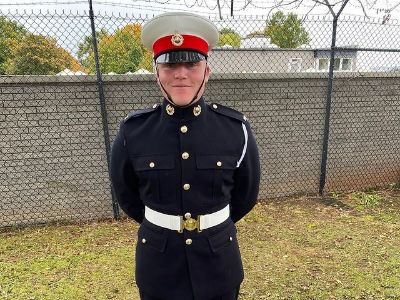 Jack Scott Ramsay is standing straight with both his hands behind his back.